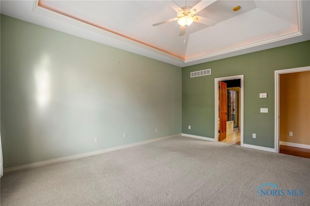14579 Lake Meadows Dr, Perrysburg, OH 43551 - spare room featuring visible vents, baseboards, a ceiling fan, light carpet, and a tray ceiling