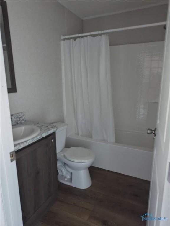 600 S Union St, Bryan, OH 43506 - bathroom featuring shower / bathtub combination with curtain, wood finished floors, toilet, and vanity