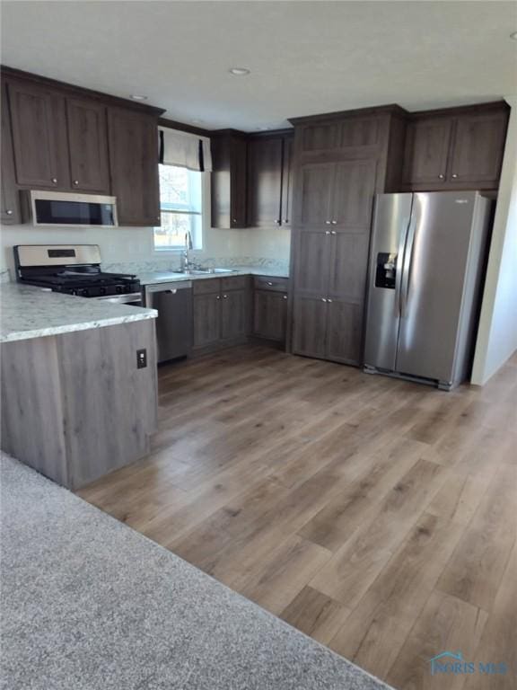 600 S Union St, Bryan, OH 43506 - kitchen with a sink, dark brown cabinetry, appliances with stainless steel finishes, and light wood finished floors