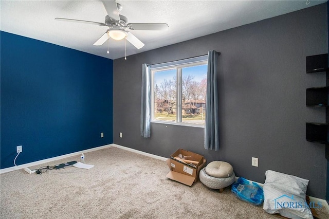 interior space with carpet floors, baseboards, and ceiling fan