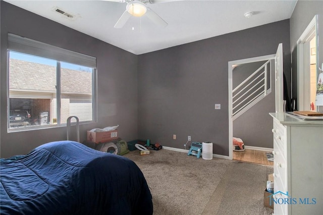 carpeted bedroom featuring baseboards, ceiling fan, and visible vents