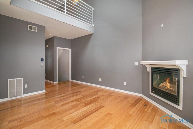 4014 Stonehenge Dr Unit 4014, Sylvania, OH 43560 - unfurnished living room featuring wood finished floors, a glass covered fireplace, and baseboards