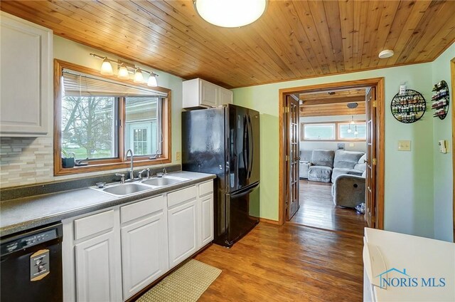 406 N Main St, Continental, OH 45831 - kitchen featuring white cabinetry, decorative backsplash, a sink, black appliances, and wood finished floors