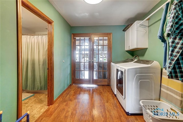 406 N Main St, Continental, OH 45831 - washroom featuring cabinet space, french doors, washer and clothes dryer, and light wood finished floors