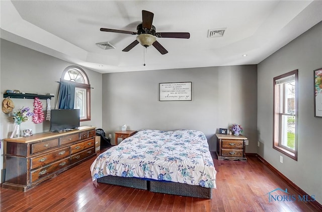 406 N Main St, Continental, OH 45831 - bedroom with hardwood / wood-style flooring, a tray ceiling, multiple windows, and visible vents