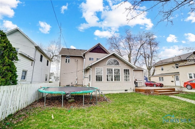 406 N Main St, Continental, OH 45831 - rear view of house featuring fence, a trampoline, crawl space, and a yard