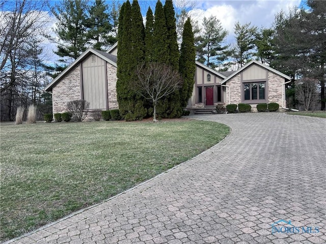 mid-century home with brick siding, curved driveway, and a front yard