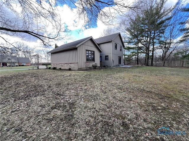 view of property exterior with a lawn and board and batten siding