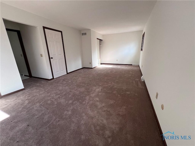 carpeted spare room featuring baseboards and visible vents