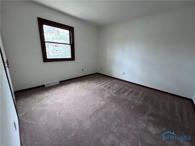 carpeted spare room with baseboards and visible vents
