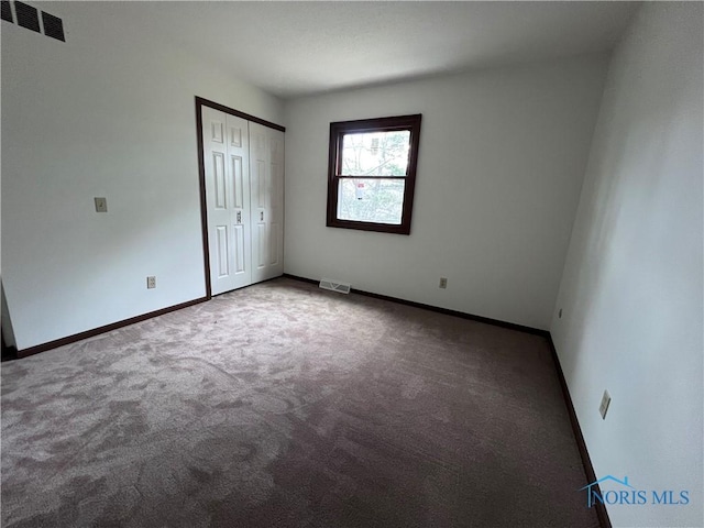 unfurnished bedroom featuring a closet, carpet, baseboards, and visible vents