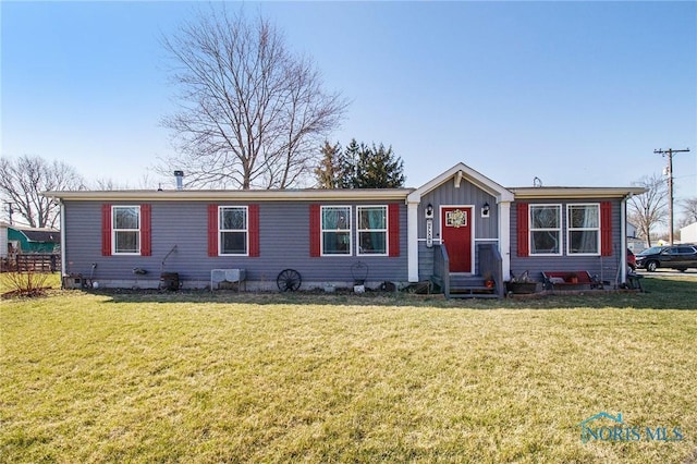 900 E Water St, North Baltimore, OH 45872 - view of front facade with board and batten siding, entry steps, and a front lawn