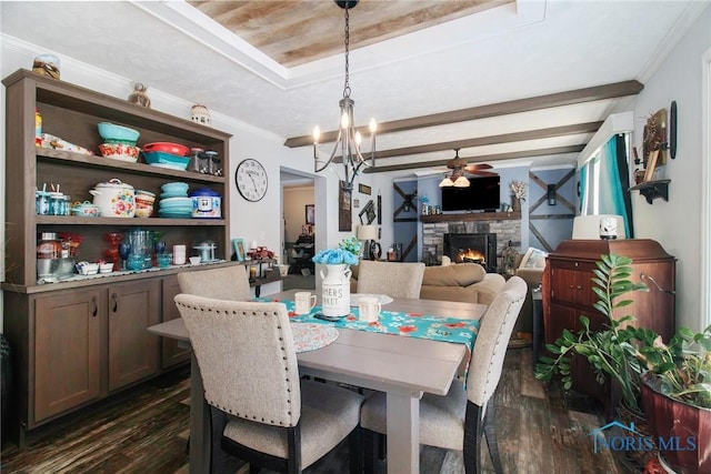 900 E Water St, North Baltimore, OH 45872 - dining area featuring dark wood-style floors, ceiling fan with notable chandelier, a stone fireplace, and crown molding