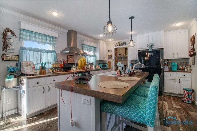 900 E Water St, North Baltimore, OH 45872 - kitchen with wall chimney range hood, dark countertops, crown molding, and white cabinetry