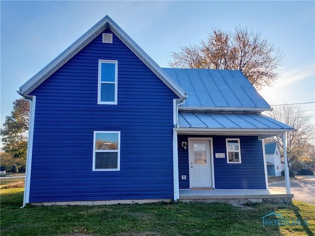 300 Plum St, Columbus Grove, OH 45830 - view of front of house featuring a front lawn, metal roof, covered porch, and a standing seam roof