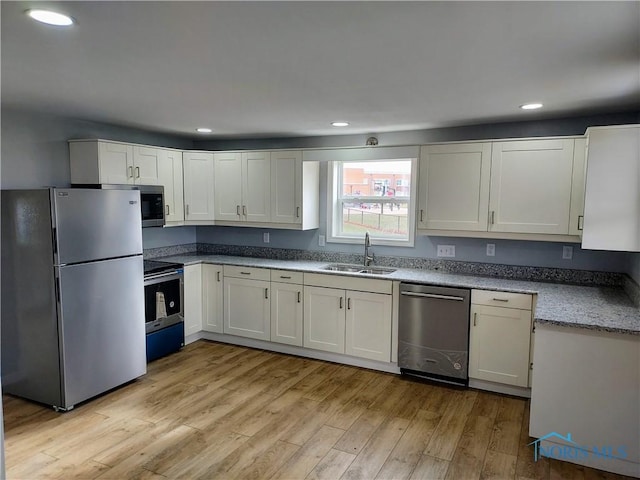 300 Plum St, Columbus Grove, OH 45830 - kitchen featuring a sink, appliances with stainless steel finishes, light wood-style flooring, white cabinets, and recessed lighting
