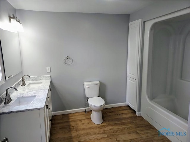 300 Plum St, Columbus Grove, OH 45830 - full bath featuring baseboards, double vanity, toilet, wood finished floors, and a sink