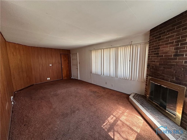 41 Dickens Dr, Toledo, OH 43607 - unfurnished living room featuring a fireplace, wood walls, and carpet floors