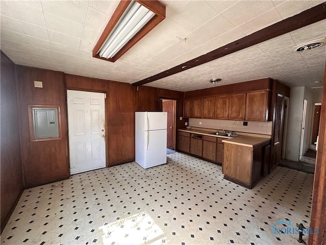 41 Dickens Dr, Toledo, OH 43607 - kitchen featuring light countertops, a sink, wooden walls, freestanding refrigerator, and electric panel