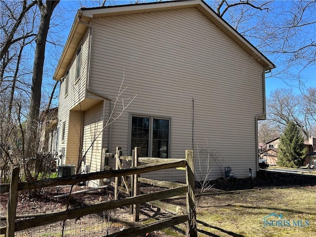 view of side of home featuring fence