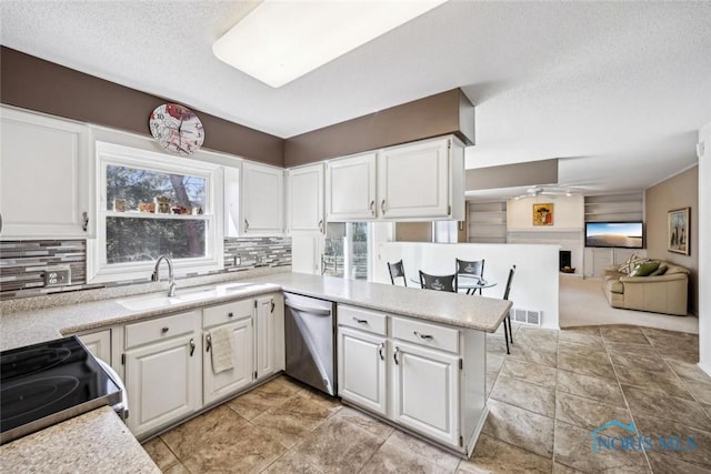 kitchen with light countertops, white cabinets, tasteful backsplash, appliances with stainless steel finishes, and a sink