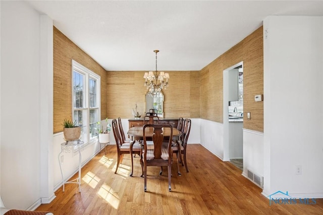dining area featuring visible vents, a chandelier, and light wood finished floors