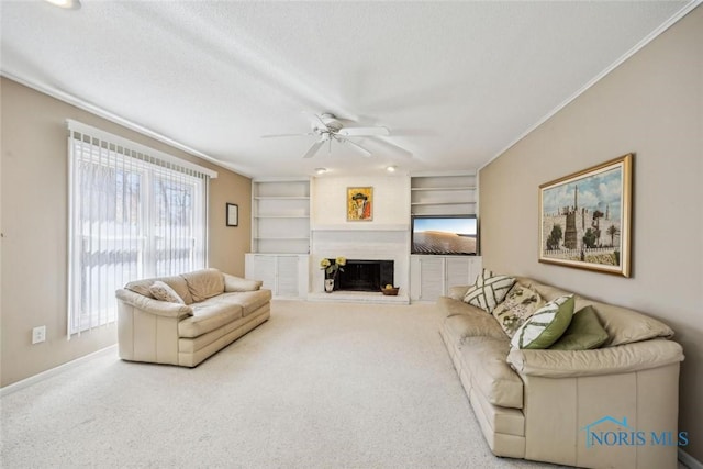living room with carpet flooring, a ceiling fan, crown molding, and a textured ceiling