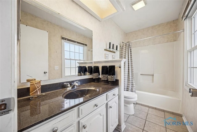 bathroom featuring a wealth of natural light, toilet, tile patterned flooring, and vanity