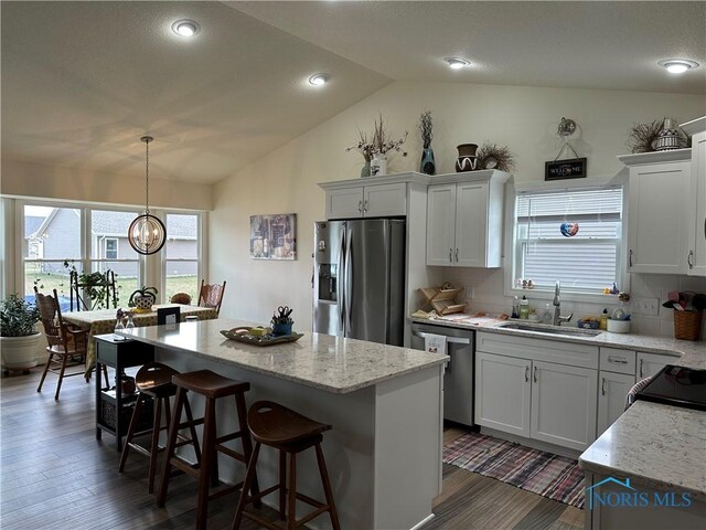 9277 Colonel Dr, Findlay, OH 45840 - kitchen featuring a breakfast bar area, lofted ceiling, stainless steel appliances, a center island, and a sink