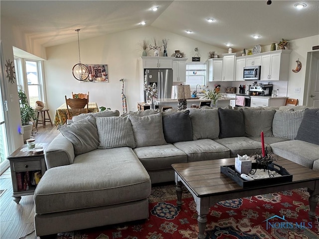 9277 Colonel Dr, Findlay, OH 45840 - living area with vaulted ceiling, an inviting chandelier, wood finished floors, and plenty of natural light