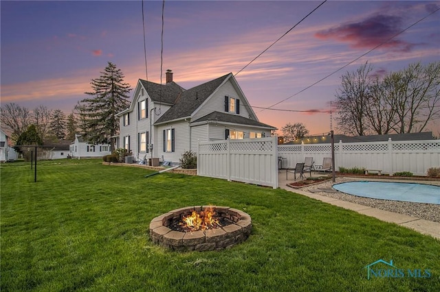 400 W St, Archbold, OH 43502 - yard at dusk with a fenced in pool, fence, central AC, a patio, and a fire pit