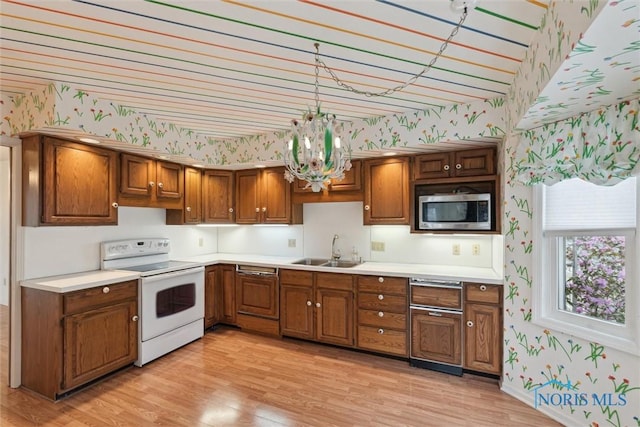 kitchen with white electric stove, a sink, stainless steel microwave, light wood-style floors, and wallpapered walls