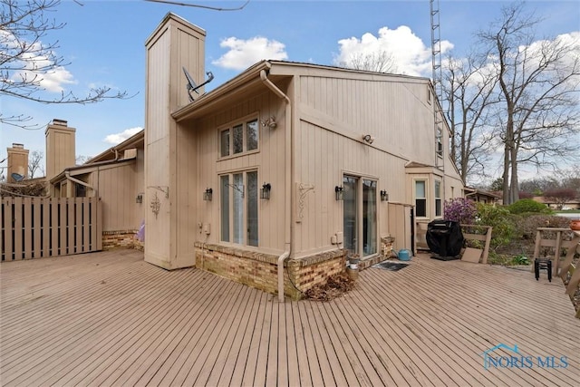 back of house featuring a chimney and a deck