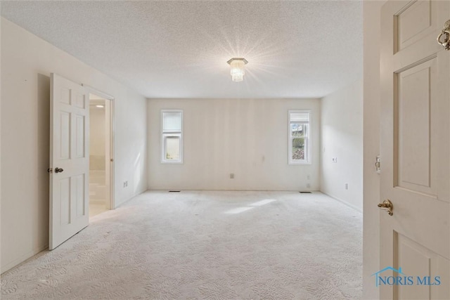 empty room with carpet and a textured ceiling