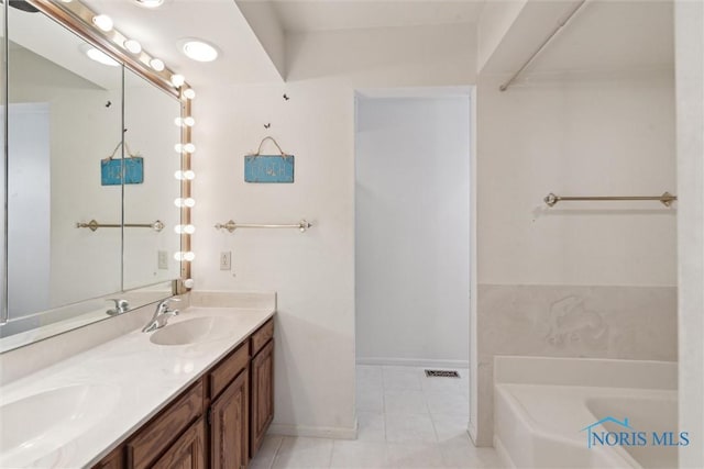 full bath with tile patterned flooring, a tub to relax in, a sink, and double vanity