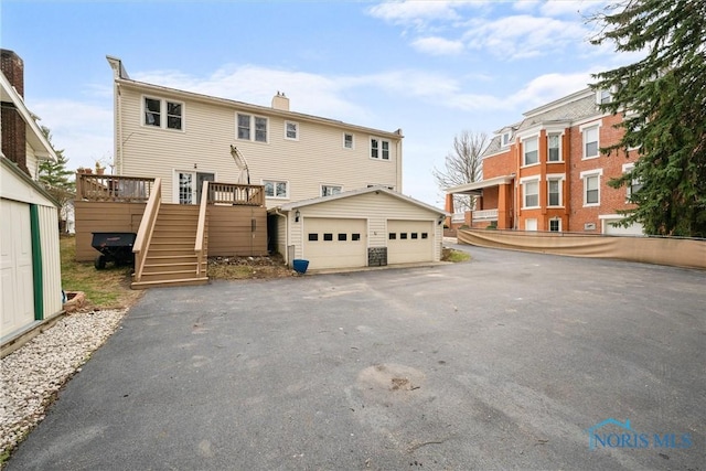 634 Holgate Ave, Defiance, OH 43512 - back of house with an outdoor structure, stairs, a deck, and a chimney