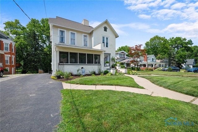 634 Holgate Ave, Defiance, OH 43512 - view of front of home featuring a front yard, a chimney, and stucco siding