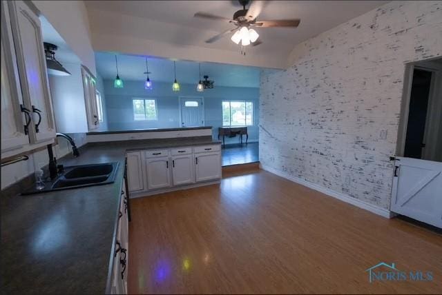 3844 Washburn Rd, Berkey, OH 43504 - kitchen with a sink, ceiling fan, baseboards, wood finished floors, and dark countertops