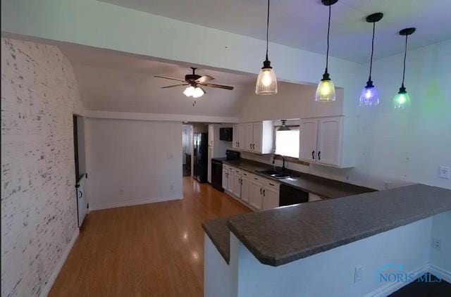 3844 Washburn Rd, Berkey, OH 43504 - kitchen featuring dark countertops, light wood finished floors, a sink, white cabinetry, and hanging light fixtures