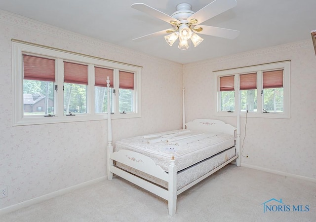 bedroom with multiple windows, wallpapered walls, and light colored carpet