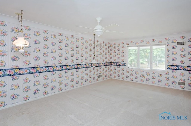 unfurnished room featuring carpet flooring, wallpapered walls, baseboards, and ceiling fan