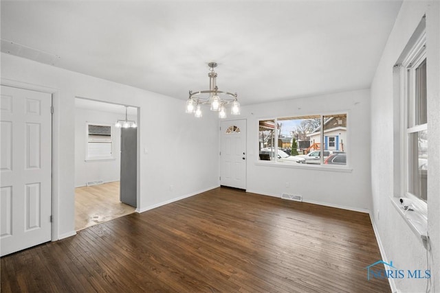 216 Licking St, Toledo, OH 43605 - unfurnished dining area with a chandelier, wood finished floors, and baseboards