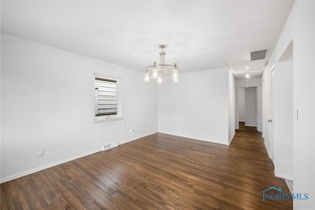 216 Licking St, Toledo, OH 43605 - empty room featuring attic access, dark wood-style flooring, baseboards, and a chandelier