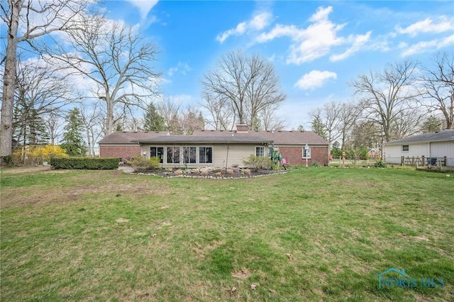 back of house with a yard, fence, and a chimney