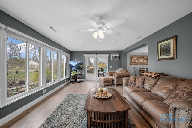 living room featuring baseboards, recessed lighting, a ceiling fan, visible vents, and wood finished floors
