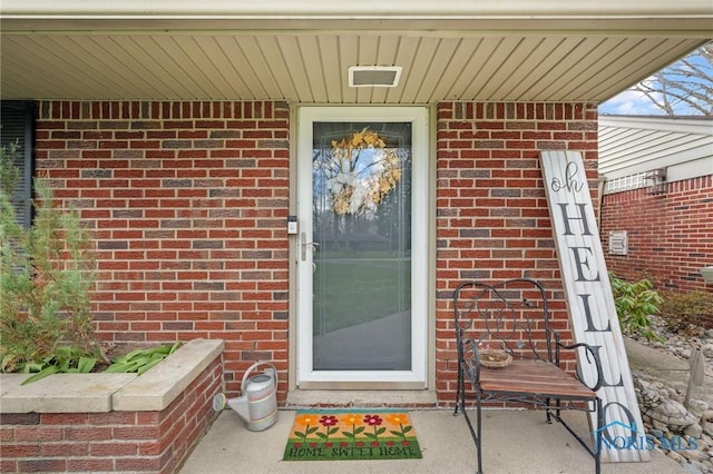 doorway to property featuring brick siding