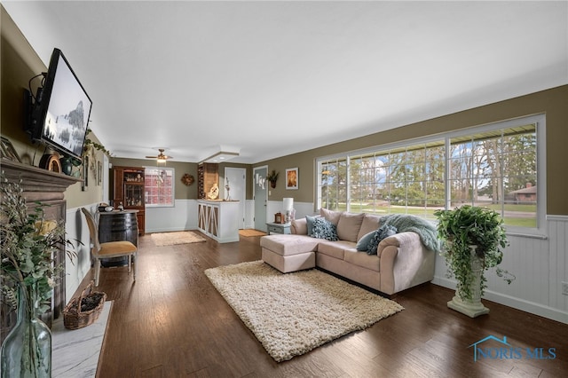 living area featuring a wainscoted wall and wood finished floors