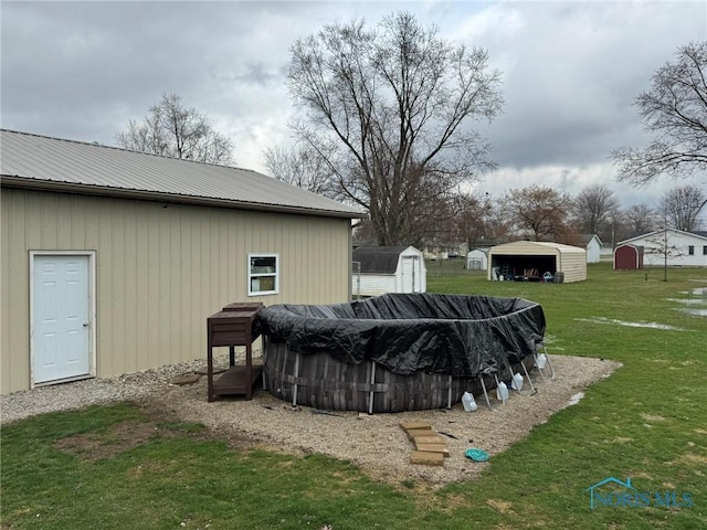view of pool with a lawn, an outbuilding, and a shed