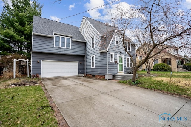 view of front of house with a front yard, an attached garage, and concrete driveway