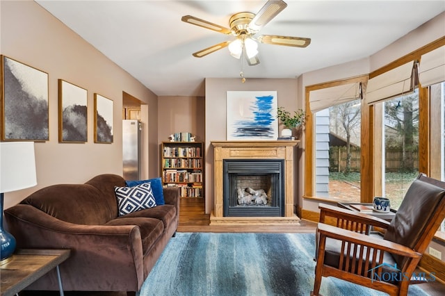living room with wood finished floors, a fireplace, and ceiling fan